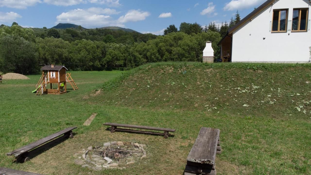 Ławki wokół miejsca na ognisko, obok plac zabaw