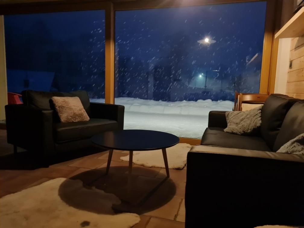 Salon zimowym wieczorem, za szybą pada śnieg